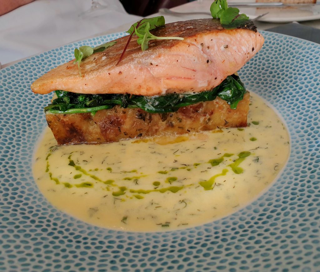 salmon with crushed new potato terrine, buttered spinach, and a champagne and dill butter sauce 